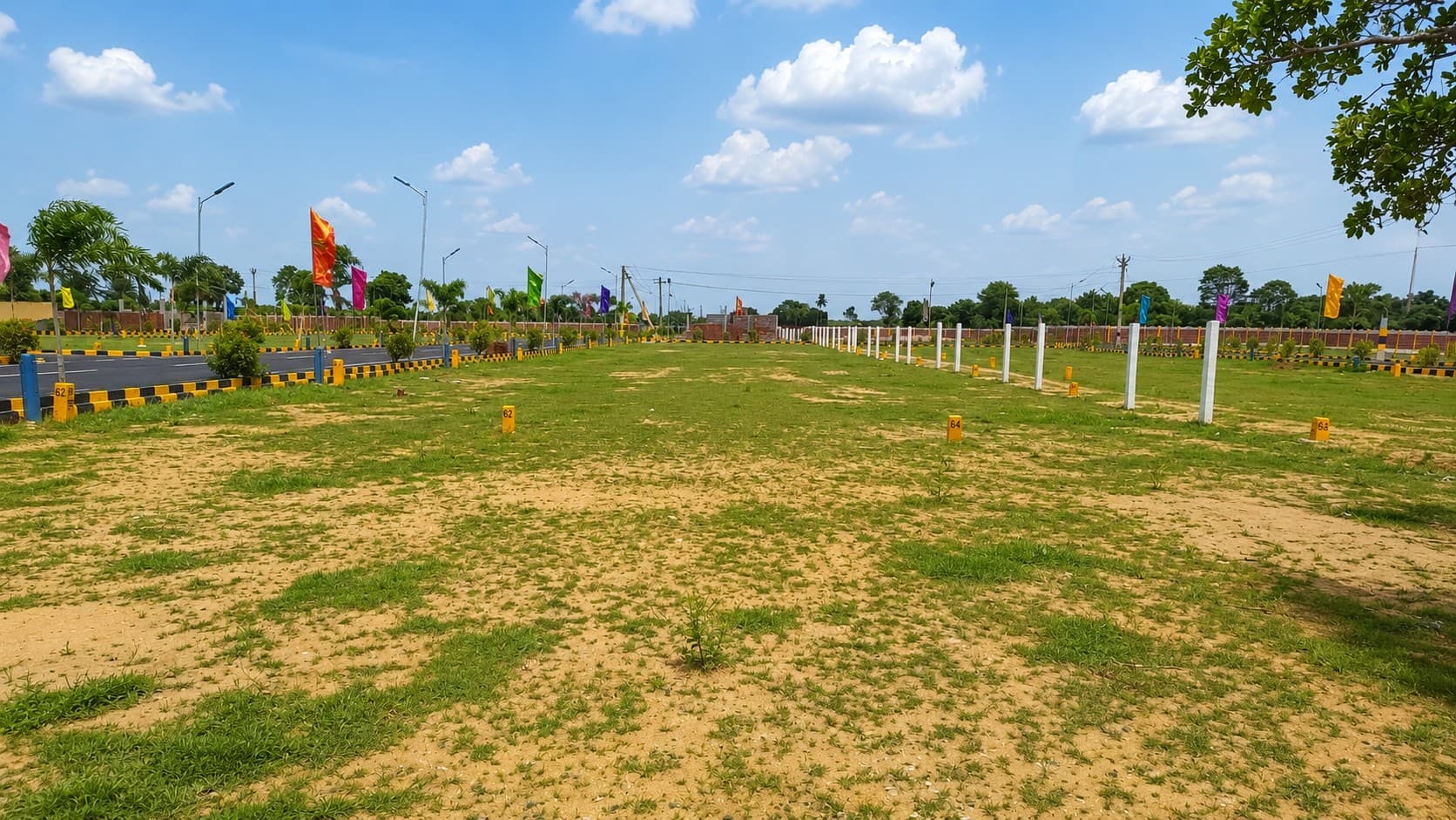 Numbered, marked-out plots with kerb stones and flag markers at Sri Krithvik Garden